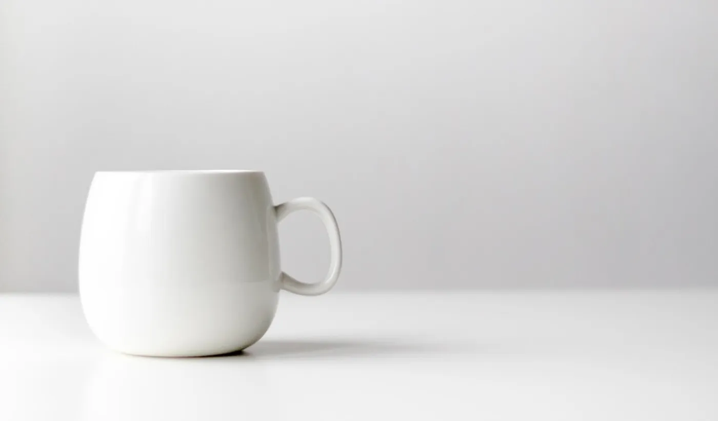 White ceramic coffee mug on a dark surface
