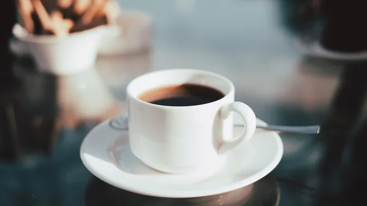 Cup of coffee on a white ceramic saucer