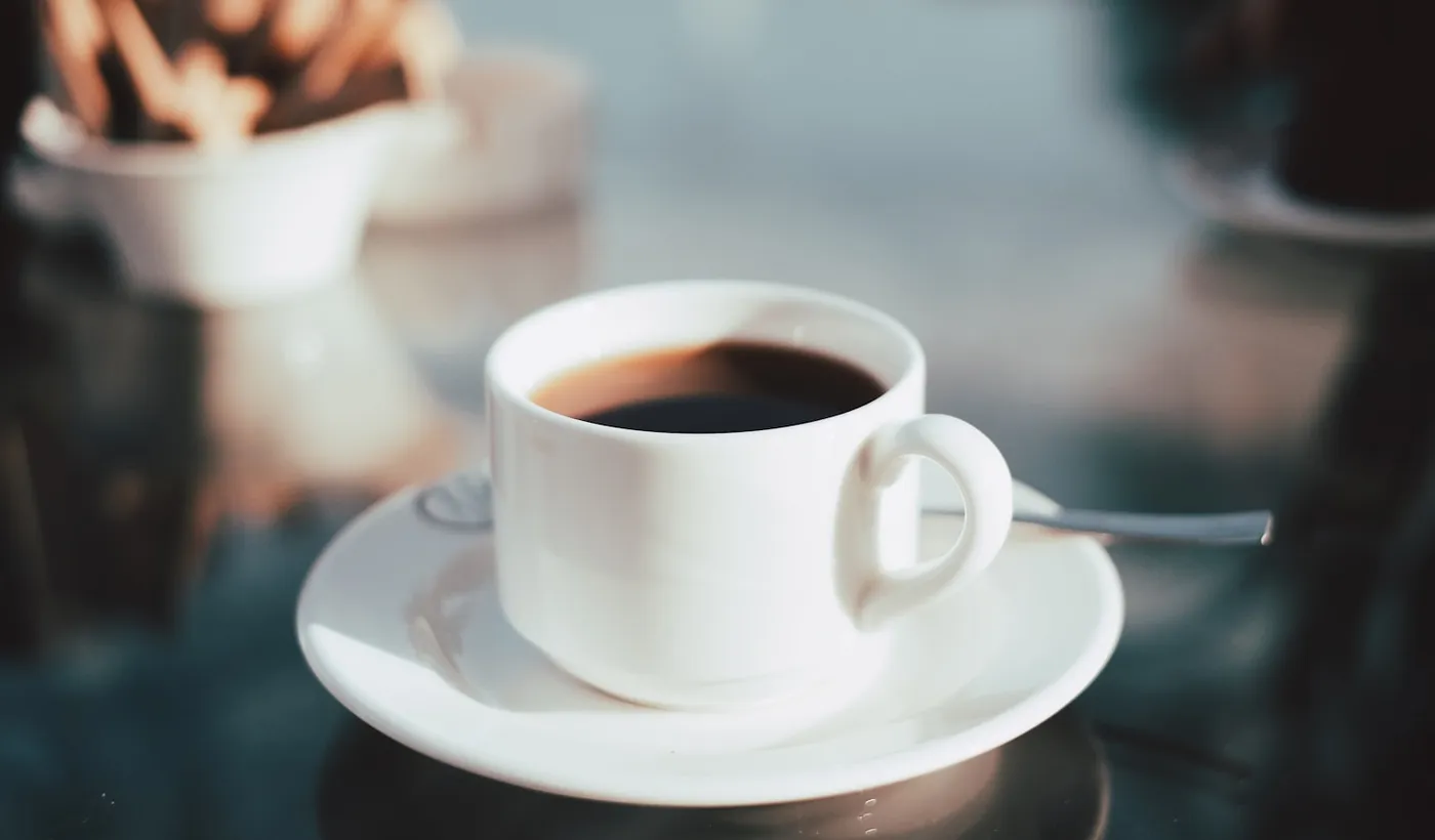 Cup of coffee on a white ceramic saucer