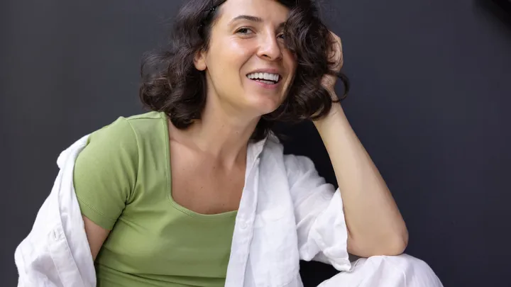Woman holding her head while considering complex migraine symptoms