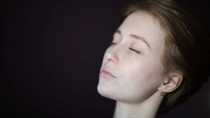 Woman looking upward while experiencing a persistent constant headache