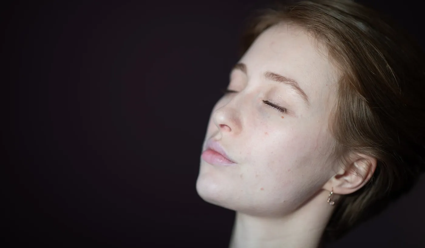 Woman looking upward while experiencing a persistent constant headache