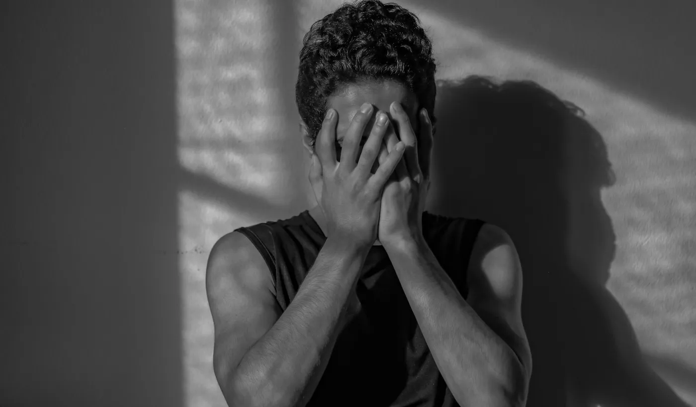 Man covering his face while experiencing head pain