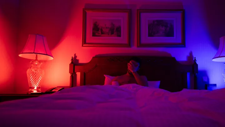 Person resting in bed while dealing with frequent recurring headaches