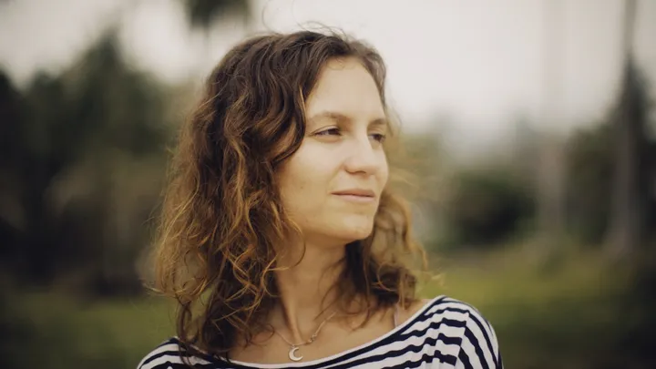 Woman looking into the distance while noticing early migraine symptoms