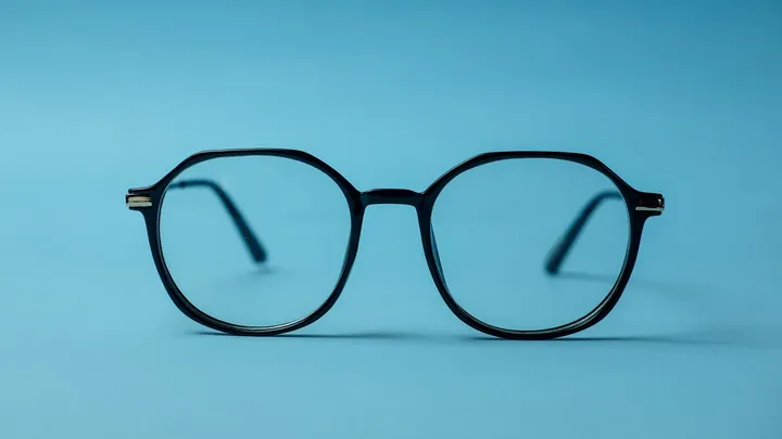 Black framed eyeglasses resting on a bright white surface