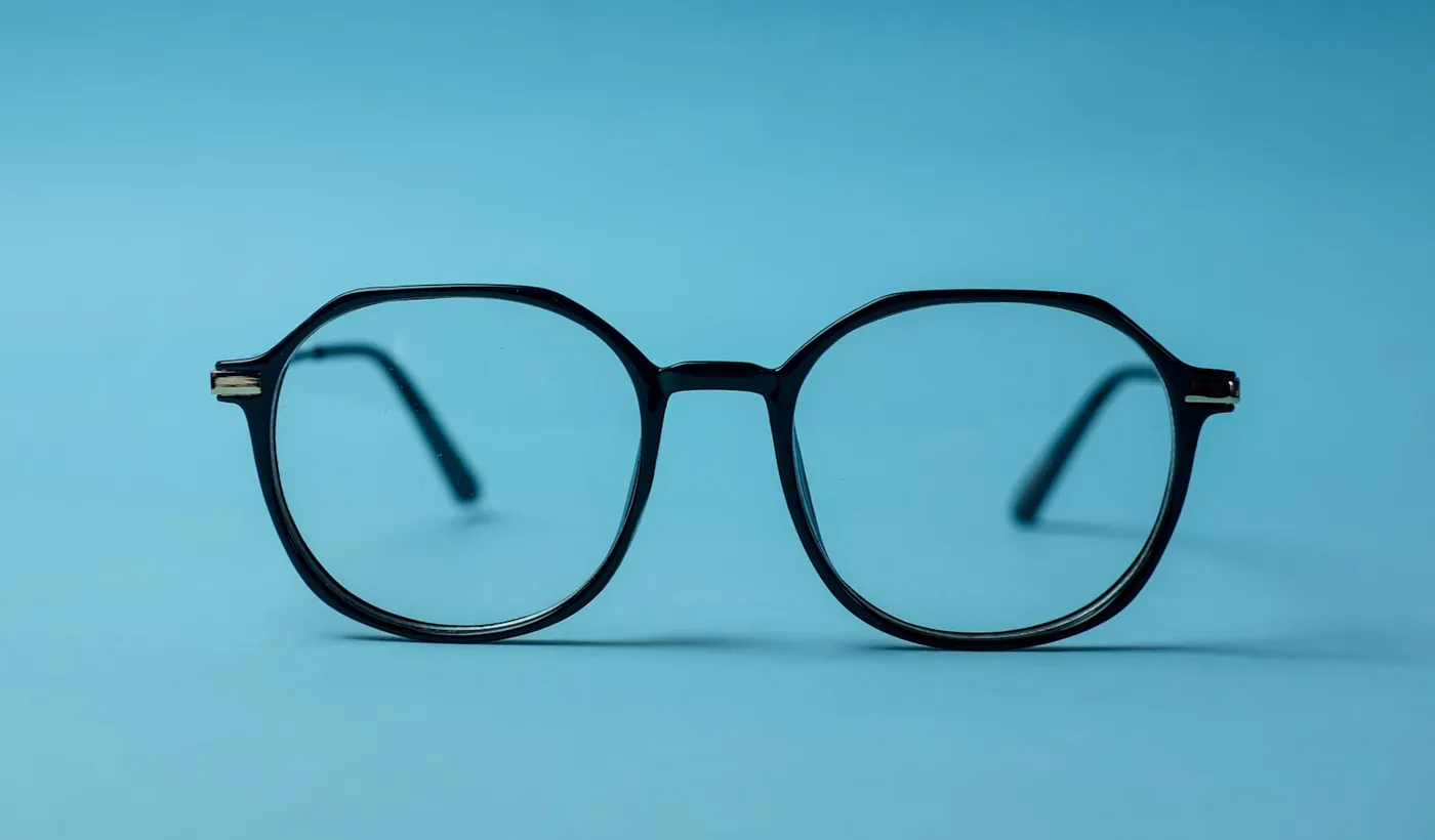 Black framed eyeglasses resting on a bright white surface