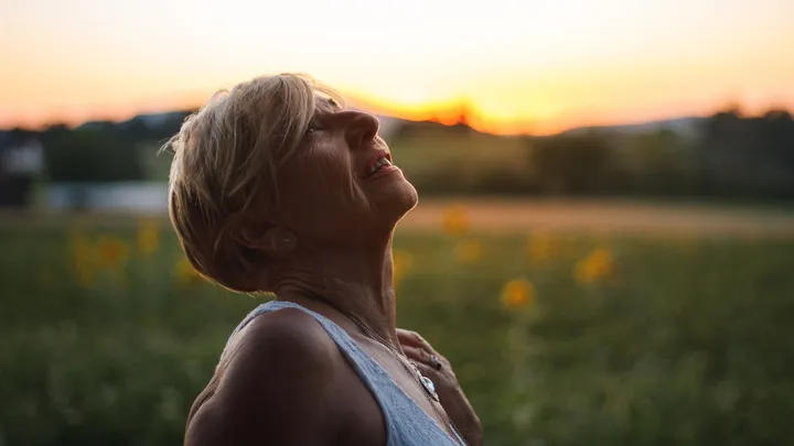 Woman resting outdoors while recovering from frequent rebound headaches