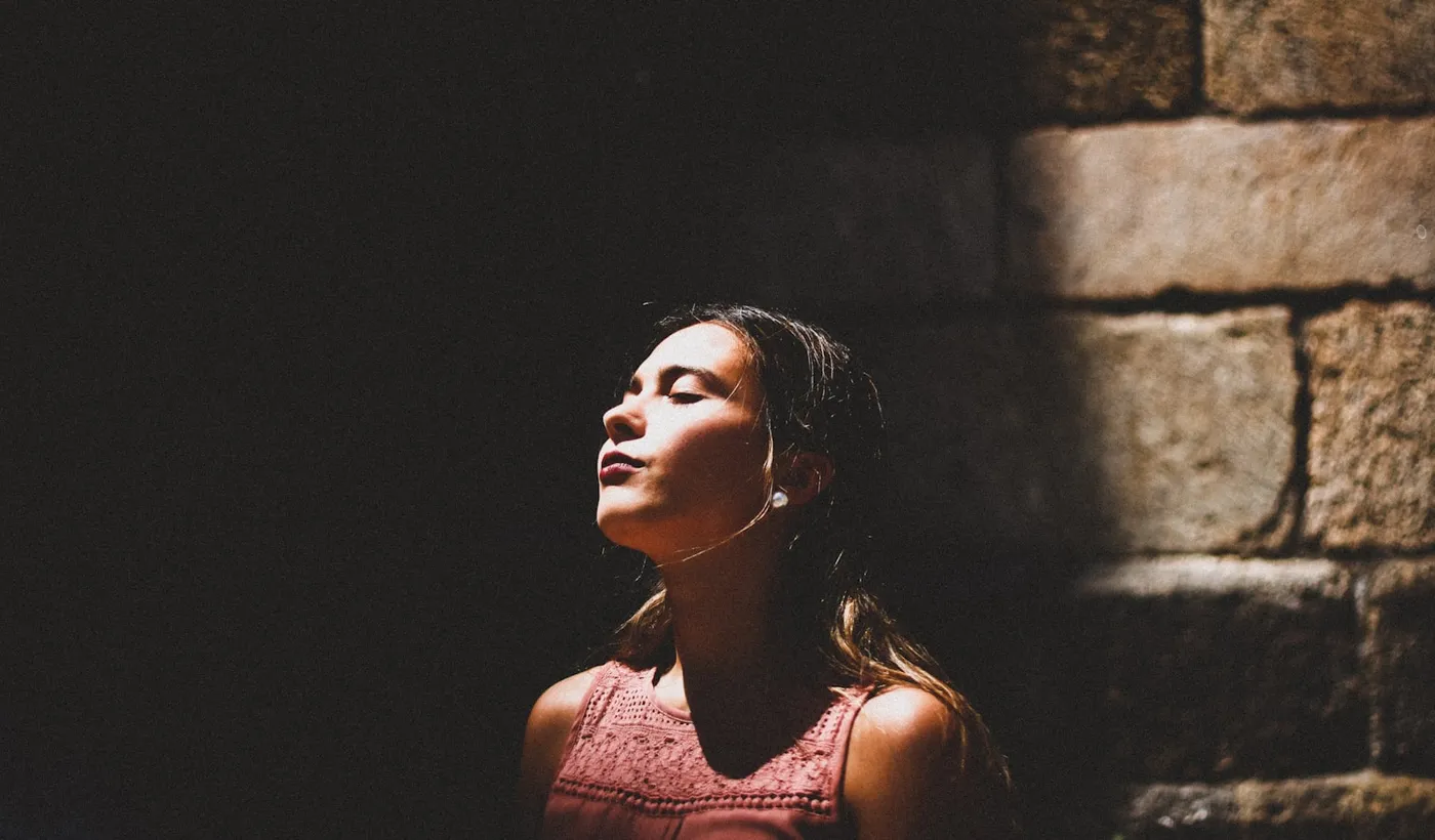 Woman pausing in soft light during a silent migraine aura without headache