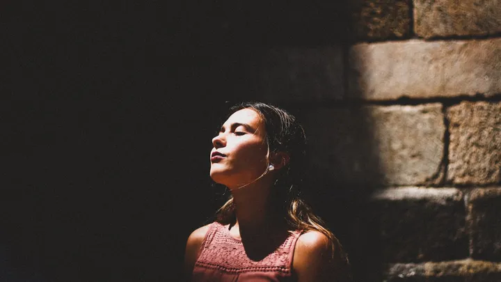 Woman pausing in soft light during a silent migraine aura without headache